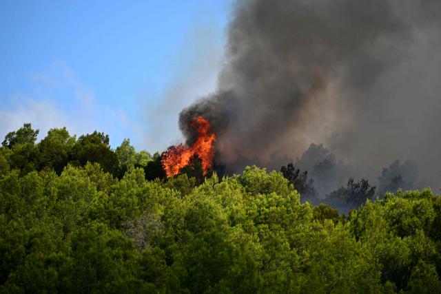 This photograph shows a fire in mountain ranges during a wildfire in Pouzols-Minervois, southern France on July 2, 2026. One year after the wildfire in the Corbières massif, the south of France has once again been hit by a large-scale blaze that broke out July 1, 2026 afternoon in the Herault before quickly spreading to the neighboring department of Aude under the combined effect of drought and wind, and is being fought by hundreds of firefighters. (Photo by Lionel BONAVENTURE / AFP)