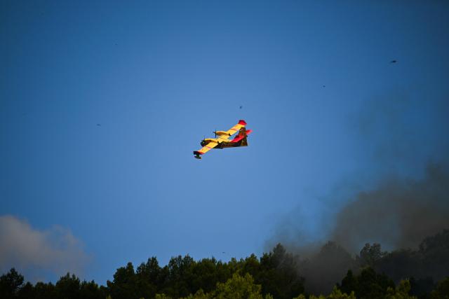 A Canadair aircraft flies during a wildfire in Pouzols-Minervois, southern France on July 2, 2026. One year after the wildfire in the Corbières massif, the south of France has once again been hit by a large-scale blaze that broke out on July 1, 2026 afternoon in the Herault before quickly spreading to the neighboring department of Aude under the combined effect of drought and wind, and is being fought by hundreds of firefighters. (Photo by Lionel BONAVENTURE / AFP)