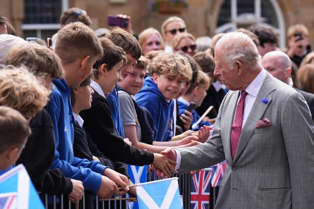 Britain's King Charles III (R) meets members of the public during a visit to coincide with the Jethart Callant Festival in Jedburgh, Scotland on July 2, 2026. (Photo by Aaron Chown / POOL / AFP)