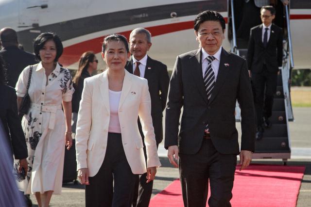 Singapore's Prime Minister Laurence Wong and his wife Loo Tze Lui are welcomed upon their arrival at Presidente Nicolau Lobato International Airport in Dili on July 2, 2026. (Photo by Valentino Dariell DE SOUSA / AFP)