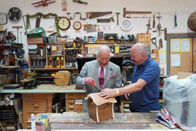 Britain's King Charles III (L) helps to assemble a roof on a birdhouse at Jed Shed during a visit to coincide with the Jethart Callant Festival in Jedburgh, Scotland on July 2, 2026. (Photo by Aaron Chown / POOL / AFP)