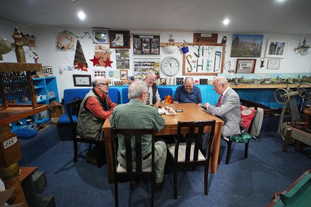 Britain's King Charles III (R) sits down to chat with members of the public in the Jed Shed during a visit to coincide with the Jethart Callant Festival in Jedburgh, Scotland on July 2, 2026. (Photo by Aaron Chown / POOL / AFP)