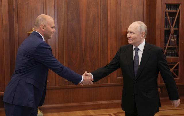 In this pool photograph distributed by the Russian state agency Sputnik, Russia's President Vladimir Putin shakes hands with the Kaliningrad region governor Alexei Besprozvannykh during a meeting in Moscow on July 2, 2026. (Photo by Gavriil Grigorov / POOL / AFP)
