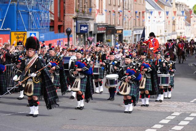 A marching band perform whilst a procession of horses ride past the town square during a visit by Britain's King Charles III to coincide with the Jethart Callant Festival in Jedburgh, Scotland on July 2, 2026. (Photo by Aaron Chown / POOL / AFP)