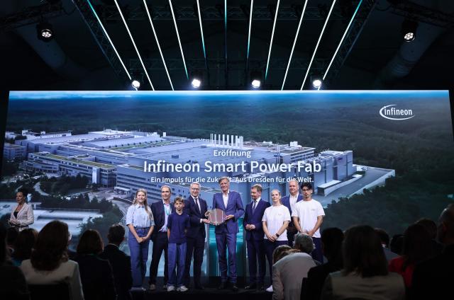 (3rd-R) German Minister for Digitalization and State Modernization Karsten Wildberger, CEO of Infineon Jochen Hanebeck and Saxony's State Premier Michael Kretschmer pose with a 300mm wafer during the opening ceremony of the Infineon Smart Power Fab in Dresden, eastern Germany, on July 2, 2026. German semiconductor giant Infineon officially opens a large new chip factory in eastern Germany on July 2, three months ahead of schedule. The new, highly automated plant -- which cost 5 billion euros ($5.7 billion) -- has been repeatedly held up as a symbol of the European Union's push to bolster the domestic tech sector and reduce dependency for crucial parts on Asia and the United States. (Photo by Ronny HARTMANN / AFP)