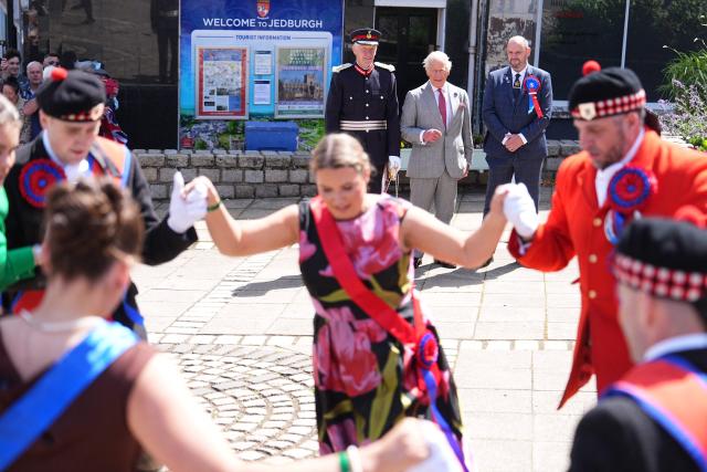Dancers perform during a visit by Britain's King Charles III (behind C), during a visit to coincide with the Jethart Callant Festival in Jedburgh, Scotland on July 2, 2026. (Photo by Aaron Chown / POOL / AFP)