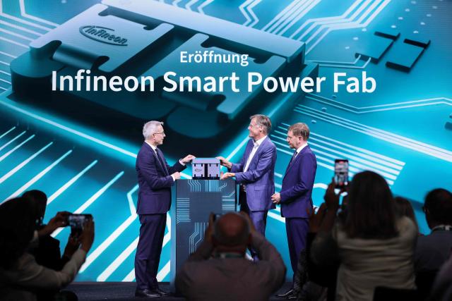 (L-R) German Minister for Digitalization and State Modernization Karsten Wildberger, CEO of Infineon Jochen Hanebeck and Saxony's State Premier Michael Kretschmer unveil a 300mm wafer during the opening ceremony of the Infineon Smart Power Fab in Dresden, eastern Germany, on July 2, 2026. German semiconductor giant Infineon officially opens a large new chip factory in eastern Germany on July 2, three months ahead of schedule. The new, highly automated plant -- which cost 5 billion euros ($5.7 billion) -- has been repeatedly held up as a symbol of the European Union's push to bolster the domestic tech sector and reduce dependency for crucial parts on Asia and the United States. (Photo by Ronny HARTMANN / AFP)