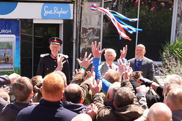 Britain's King Charles III (behind C) starts a traditional game of hand ba', during a visit to coincide with the Jethart Callant Festival in Jedburgh, Scotland on July 2, 2026. (Photo by Aaron Chown / POOL / AFP)