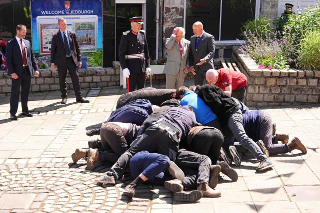 Britain's King Charles III (back C) watches a traditional game of hand ba', during a visit to coincide with the Jethart Callant Festival in Jedburgh, Scotland on July 2, 2026. (Photo by Aaron Chown / POOL / AFP)