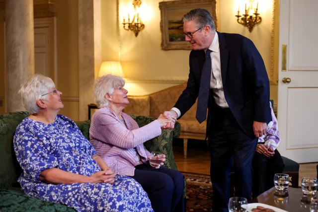 Britain's Prime Minister Keir Starmer (R) shakes hands with former Labour Member of Parliament Ann Keen (C), who was forced to give up her baby boy for adoption at the age of 17, as he welcomes her and other campaigners for a meeting to discuss historical forced adoption, at Downing Street in London on July 2, 2026. (Photo by Isabel Infantes / POOL / AFP)