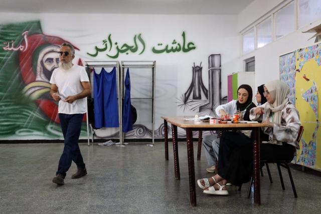 Election officials sit as a man prepares to cast his ballot during parliamentary elections in Algiers on July 2, 2026. Algerians headed to the polls on July 2 to elect a new parliament in an election shadowed by expectations of low turnout among the 25-million-person electorate. (Photo by AFP)