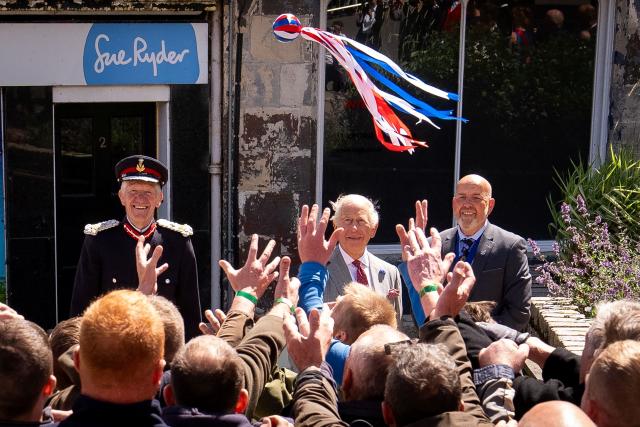 Britain's King Charles III (behind C) starts a traditional game of hand ba', during a visit to coincide with the Jethart Callant Festival in Jedburgh, Scotland on July 2, 2026. (Photo by Aaron Chown / POOL / AFP)