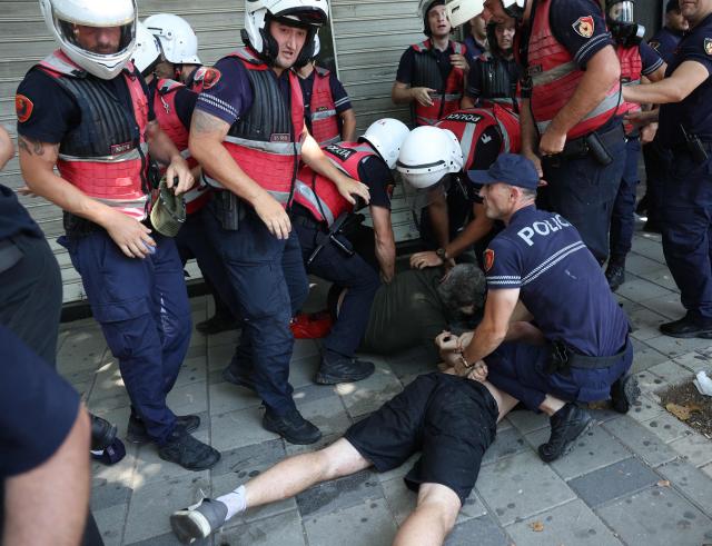 Police detain a protester as violent clashes erupted between police and demonstrators on the sidelines of a demonstration against a controversial luxury resort development linked to US President near a protected natural area, outside the parliament, in Tirana, on July 2, 2026. Since late May, protests have been held against the construction of a luxury hotel linked to Donald Trump's daughter and her husband in a nature reserve in Zvernec, on Albania's southwestern coast. For the second time this week, large groups of protesters had gathered outside the country's parliament in an attempt to confront lawmakers and block entry to the building. (Photo by Adnan Beci / AFP)