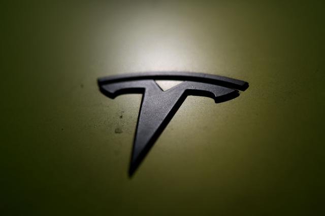 (FILES) This photograph taken on May 22, 2026 shows a Tesla logo on the body of a car belonging to an electric car rental company parked in Warsaw. Tesla reported a jump in second-quarter auto sales on July 2, 2026, as Elon Musk's electric vehicle company easily topped expectations in a period of lofty gasoline prices due to the US-Iran war. Tesla's global deliveries came in at 480,126, up 25 percent from the year-ago period when Musk's work in President Donald Trump's administration sparked consumer boycotts and protest. (Photo by Sergei GAPON / AFP)