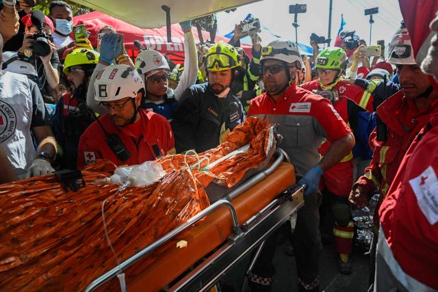 An international rescue team loads Hernan Gil, a survivor of Venezuela's twin earthquakes, into an ambulance in Catia La Mar, La Guaira State, Venezuela on July 2, 2026, eight days after the quake. Hernan Gil, a 43-year-old security guard, had been buried in the booth of the seven-story building where he worked in Catia La Mar, a coastal area in the state of La Guaira devastated by the disaster. (Photo by Federico PARRA / AFP)