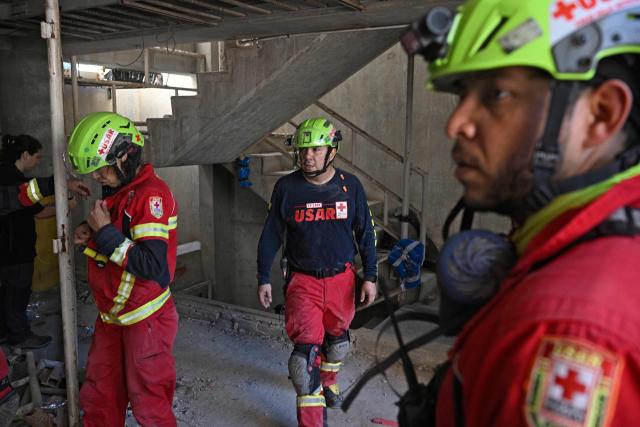 Rescue workers enter the garage of the building from which Hernan Gil was rescued in Catia La Mar, La Guaira State, Venezuela on July 2, 2026, eight days after twin earthquakes. Hundreds of rescuers in Venezuela cheered and embraced on July 2, 2026 after pulling 43-year-old Hernan Gil from the ruins of a collapsed building eight days after deadly twin earthquakes, AFP journalists witnessed. (Photo by Federico PARRA / AFP)