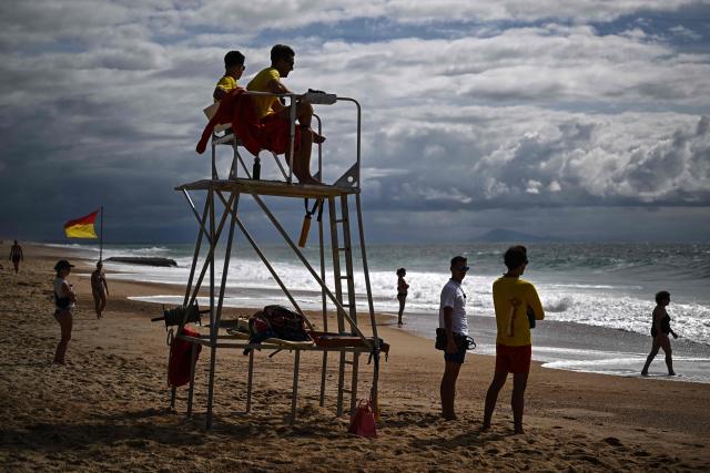 Lifeguards stay alert as they sit atop their tower and monitor bathers enjoying a warm afternoon at the beach in Labenne, south-western France on July 1, 2026. (Photo by Christophe ARCHAMBAULT / AFP)