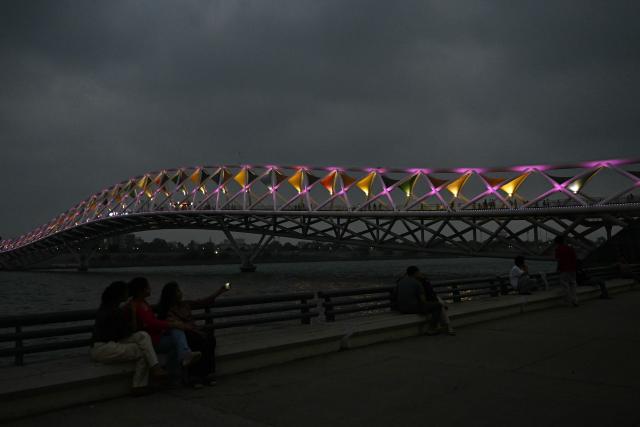 People take selfies at Sabarmati riverfront in Ahmedabad on July 2, 2026. (Photo by Shammi MEHRA / AFP)