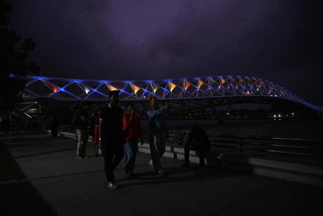 People walk at Sabarmati riverfront in Ahmedabad on July 2, 2026. (Photo by Shammi MEHRA / AFP)