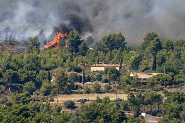 This photograph shows a wildfire raging near houses in Pouzols-Minervois, southwestern of France,  on July 2, 2026. Hundreds of firefighters are battling wildfires in the south that are being fueled by wind, drought, and heat. The largest fire is in the Aude department, but there are also fires north of Marseille, where Prime Minister is expected to chair a new interministerial crisis task force. (Photo by Idriss Bigou-Gilles / AFP)