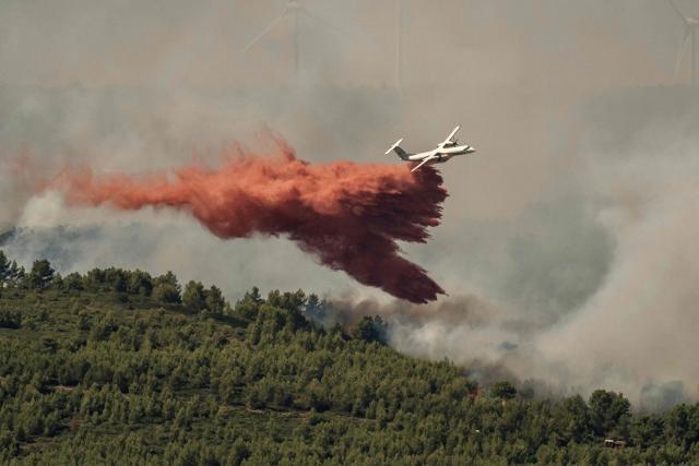 A Dash Q400-MRE Fireguard aircraft of the civil security drops retardant over a wildfire in Pouzols-Minervois, southwestern of France,  on July 2, 2026. Hundreds of firefighters are battling wildfires in the south that are being fueled by wind, drought, and heat. The largest fire is in the Aude department, but there are also fires north of Marseille, where Prime Minister is expected to chair a new interministerial crisis task force. (Photo by Idriss Bigou-Gilles / AFP)