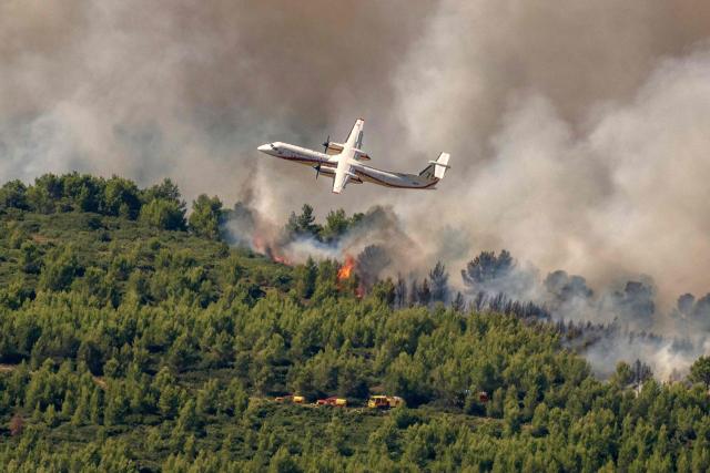 A Dash 8-Q400MR Fireguard aircraft of the civil security drops water over a wildfire in Pouzols-Minervois, southwestern of France,  on July 2, 2026. Hundreds of firefighters are battling wildfires in the south that are being fueled by wind, drought, and heat. The largest fire is in the Aude department, but there are also fires north of Marseille, where Prime Minister is expected to chair a new interministerial crisis task force. (Photo by Idriss Bigou-Gilles / AFP)