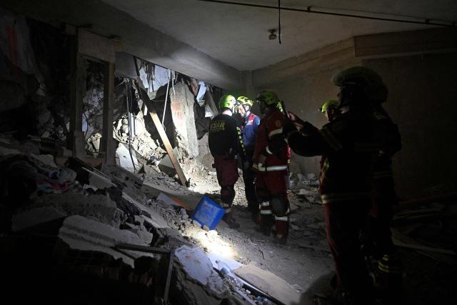 Rescue workers enter the garage of the building from which Hernan Gil was rescued in Catia La Mar, La Guaira State, Venezuela on July 2, 2026, eight days after twin earthquakes. Hundreds of rescuers in Venezuela cheered and embraced on July 2, 2026 after pulling 43-year-old Hernan Gil from the ruins of a collapsed building eight days after deadly twin earthquakes, AFP journalists witnessed. (Photo by Federico PARRA / AFP)