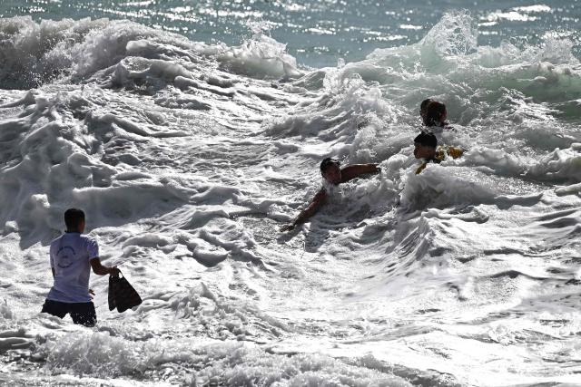 Lifeguards work to rescue bathers (Top R) caught in strong waves at the beach in Labenne, southwestern France on July 1, 2026. (Photo by Christophe ARCHAMBAULT / AFP)