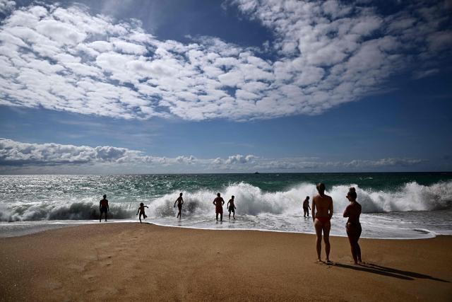 Bathers face strong waves at the beach in Labenne, southwestern France on July 1, 2026. (Photo by Christophe ARCHAMBAULT / AFP)