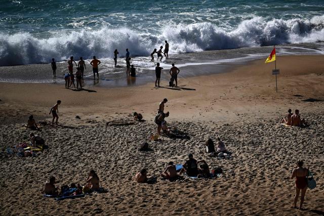 Bathers enjoy the beach as strong waves hit the shore in Labenne, southwestern France on July 1, 2026. (Photo by Christophe ARCHAMBAULT / AFP)
