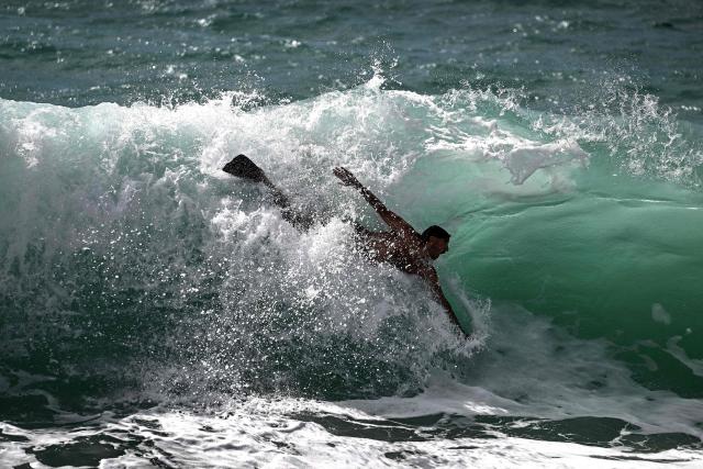 A bather swims through a big wave in Labenne, southwestern France on July 1, 2026. (Photo by Christophe ARCHAMBAULT / AFP)