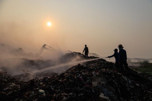 Firefighters and members of Indonesia's National Disaster Management Agency extinguish remaining fire at the Jatiwaringin landfill in Tangerang, Banten, on July 2, 2026. (Photo by ADITYA AJI / AFP)