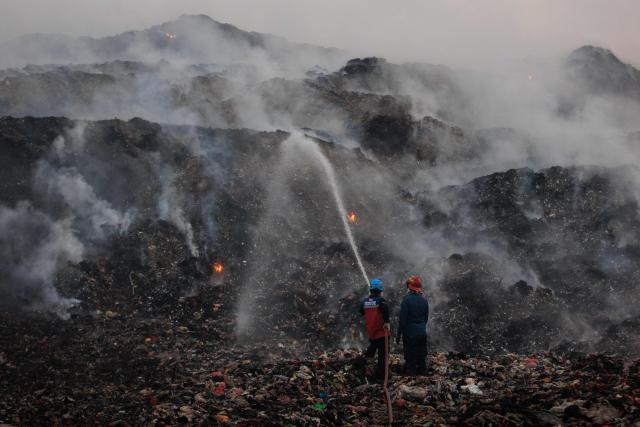 Firefighters and members of Indonesia's National Disaster Management Agency extinguish remaining fire at the Jatiwaringin landfill in Tangerang, Banten, on July 2, 2026. (Photo by ADITYA AJI / AFP)