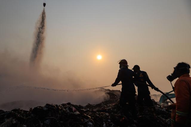 Firefighters and members of Indonesia's National Disaster Management Agency extinguish remaining fire at the Jatiwaringin landfill in Tangerang, Banten, on July 2, 2026. (Photo by ADITYA AJI / AFP)