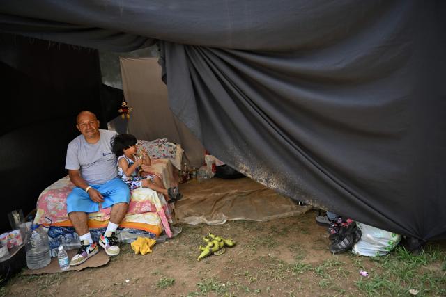 Luis Chacon remains with his son at a displaced camp at the Ali West Park in Caracas on July 2, 2026, eight days after twin earthquakes. Hundreds of rescuers in Venezuela cheered and embraced on July 2, 2026 after pulling 43-year-old Hernan Gil from the ruins of a collapsed building eight days after deadly twin earthquakes, AFP journalists witnessed. (Photo by MARTIN BERNETTI / AFP)