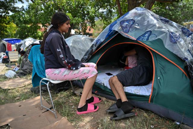 A family remains at a displaced camp at the Ali West Park in Caracas on July 2, 2026, eight days after twin earthquakes. Hundreds of rescuers in Venezuela cheered and embraced on July 2, 2026 after pulling 43-year-old Hernan Gil from the ruins of a collapsed building eight days after deadly twin earthquakes, AFP journalists witnessed. (Photo by MARTIN BERNETTI / AFP)