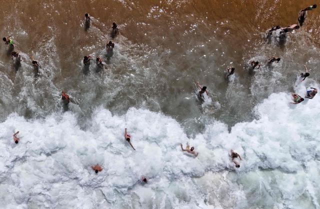 This aerial photograph shows bathers enjoying the beach in Labenne, southwestern France on July 2, 2026. (Photo by Christophe ARCHAMBAULT / AFP)