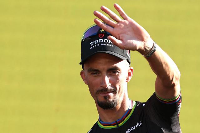 Tudor Pro Cycling Team's French rider Julian Alaphilippe waves as he and his teammates attend the team presentation ceremony ahead of the 113th edition of the Tour de France cycling race, with the Sagrada Familia Basilica seen in the background, in Barcelona, northeastern Spain, on July 2, 2026. (Photo by Anne-Christine POUJOULAT / AFP)