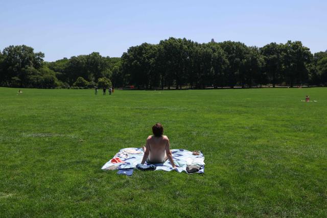 A man sunbathes on the Great Lawn in Central Park during a heatwave in New York City on July 2, 2026. Blistering temperatures and humidity gripped swaths of the United States on July 1, with the worst yet to come for the densely populated East Coast as the nation co-hosts the World Cup and prepares to celebrate its 250th birthday. "Heat dome" conditions -- in which high-pressure systems trap warm air like the lid on a pot -- persisted over the Midwest and South and were moving east, with some 46 million people under heat alerts. (Photo by TIMOTHY A. CLARY / AFP)