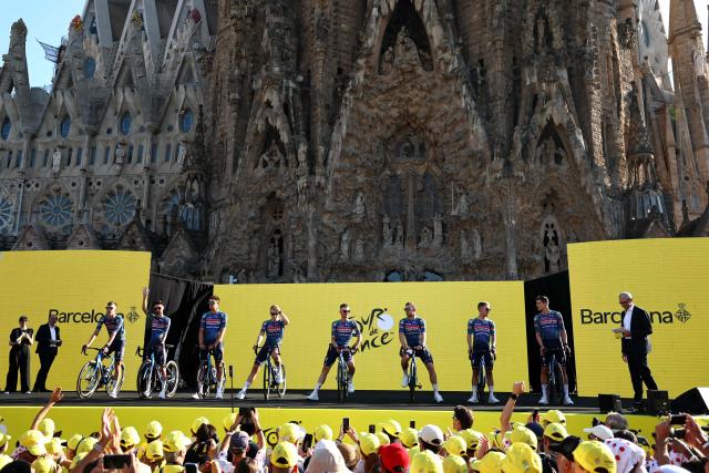 Soudal Quick-Step riders attend the team presentation ceremony ahead of the 113th edition of the Tour de France cycling race, with the Sagrada Familia Basilica  seen in the background, in Barcelona, northeastern Spain, on July 2, 2026. (Photo by Anne-Christine POUJOULAT / AFP)