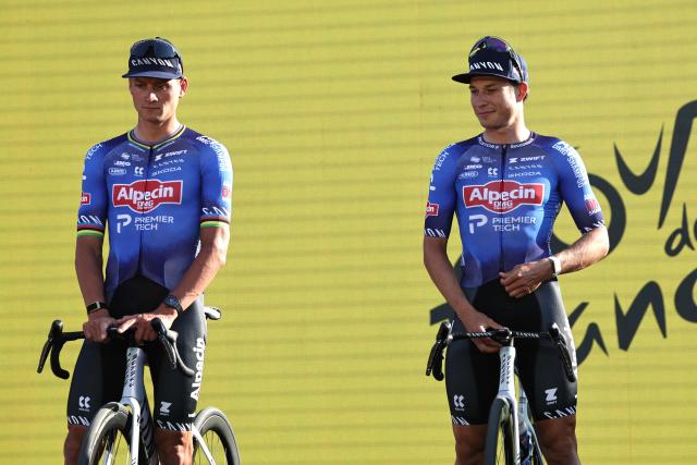 Alpecin - Premier Tech team's Dutch rider Mathieu van der Poel (L) and Alpecin - Premier Tech team's Belgian rider Jasper Philipsen attend the team presentation ceremony ahead of the 113th edition of the Tour de France cycling race, with the Sagrada Familia Basilica  seen in the background, in Barcelona, northeastern Spain, on July 2, 2026. (Photo by Anne-Christine POUJOULAT / AFP)