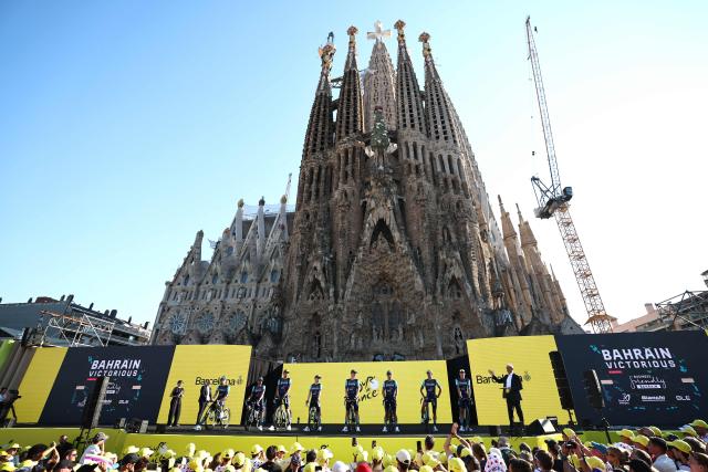 Bahrain - Victorious riders attend the team presentation ceremony ahead of the 113th edition of the Tour de France cycling race, with the Sagrada Familia Basilica  seen in the background, in Barcelona, northeastern Spain, on July 2, 2026. (Photo by Anne-Christine POUJOULAT / AFP)