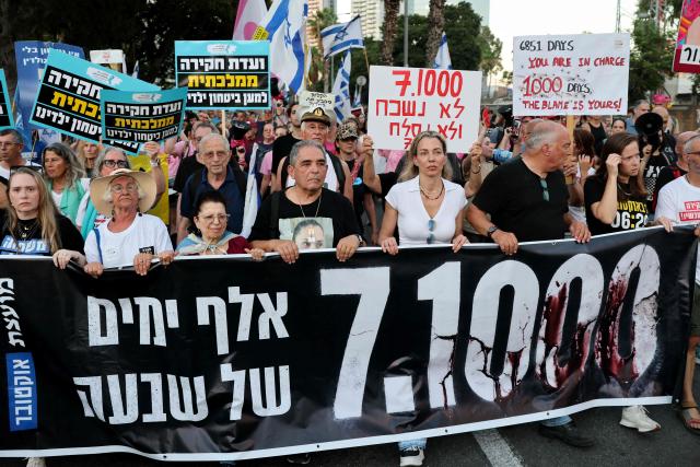 Israeli protesters hold placards during a rally against the government and the war in Gaza, at Hostage Square in Tel Aviv, on July 2, 2026, marking 1000 days since Hamas's October 7, 2023 attack on Israel. Israelis called on July 2 for a state commission of inquiry into Hamas's October 7, 2023 attack, as the country marked 1,000 days since the deadliest event in its history, which triggered the war in Gaza. A series of sombre commemorations were being held across the country, as well as protests against the government's handling of events during and after the attack. (Photo by Jack GUEZ / AFP)