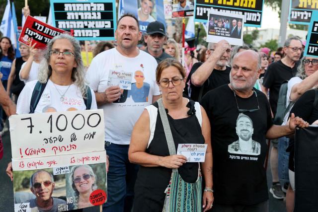Israeli protesters hold placards during a rally against the government and the war in Gaza, at Hostage Square in Tel Aviv, on July 2, 2026, marking 1000 days since Hamas's October 7, 2023 attack on Israel. Israelis called on July 2 for a state commission of inquiry into Hamas's October 7, 2023 attack, as the country marked 1,000 days since the deadliest event in its history, which triggered the war in Gaza. A series of sombre commemorations were being held across the country, as well as protests against the government's handling of events during and after the attack. (Photo by Jack GUEZ / AFP)