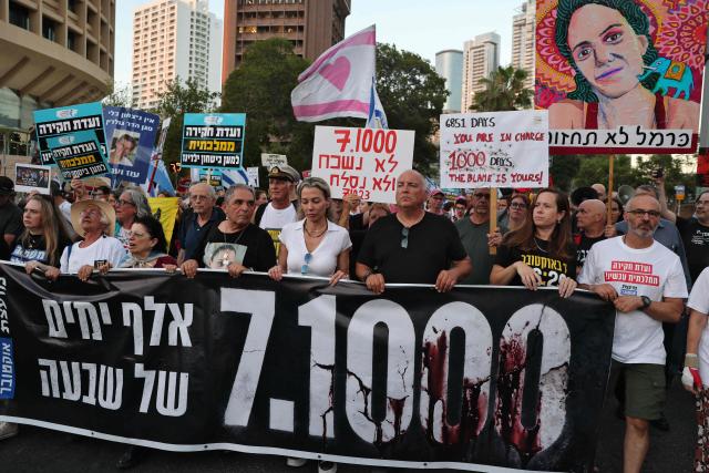 Israeli protesters hold placards during a rally against the government and the war in Gaza, at Hostage Square in Tel Aviv, on July 2, 2026, marking 1000 days since Hamas's October 7, 2023 attack on Israel. Israelis called on July 2 for a state commission of inquiry into Hamas's October 7, 2023 attack, as the country marked 1,000 days since the deadliest event in its history, which triggered the war in Gaza. A series of sombre commemorations were being held across the country, as well as protests against the government's handling of events during and after the attack. (Photo by Jack GUEZ / AFP)