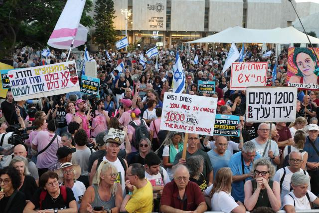 Israeli protesters hold placards during a rally against the government and the war in Gaza, at Hostage Square in Tel Aviv, on July 2, 2026, marking 1000 days since Hamas's October 7, 2023 attack on Israel. Israelis called on July 2 for a state commission of inquiry into Hamas's October 7, 2023 attack, as the country marked 1,000 days since the deadliest event in its history, which triggered the war in Gaza. A series of sombre commemorations were being held across the country, as well as protests against the government's handling of events during and after the attack. (Photo by Jack GUEZ / AFP)