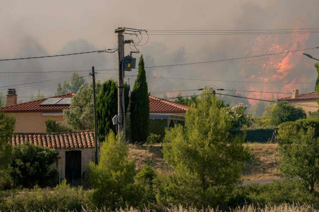 This photograph shows a wildfire raging near houses in Pouzols-Minervois, southwestern of France,  on July 2, 2026. Hundreds of firefighters are battling wildfires in the south that are being fueled by wind, drought, and heat. The largest fire is in the Aude department, but there are also fires north of Marseille, where Prime Minister is expected to chair a new interministerial crisis task force. (Photo by Idriss Bigou-Gilles / AFP)