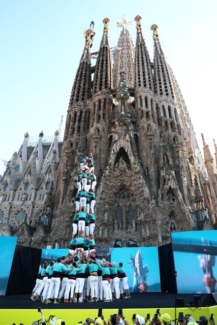Performers form a Castell, a traditional Catalan human tower, at the end of the team presentation ceremony ahead of the 113th edition of the Tour de France cycling race, with the Sagrada Familia Basilica seen in the background, in Barcelona, northeastern Spain, on July 2, 2026. (Photo by Anne-Christine POUJOULAT / AFP)