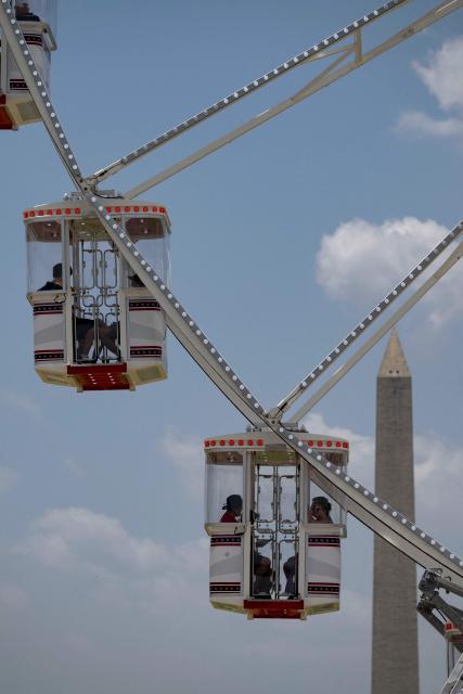 People ride the Ferris wheel as they visit the Great American State Fair on the National Mall in Washington, DC, on July 2, 2026, ahead of the upcoming July 4 holiday. (Photo by Kent Nishimura / AFP)