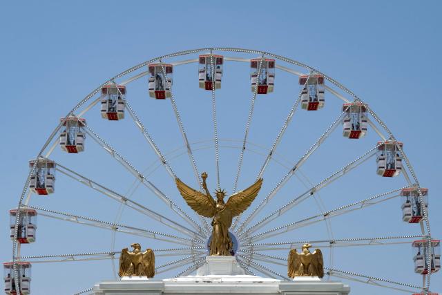The Ferris wheel and part of President Trump’s planned “Triumphal Arch” are seen as people visit the Great American State Fair on the National Mall in Washington, DC, on July 2, 2026, ahead of the upcoming July 4 holiday. (Photo by Kent Nishimura / AFP)